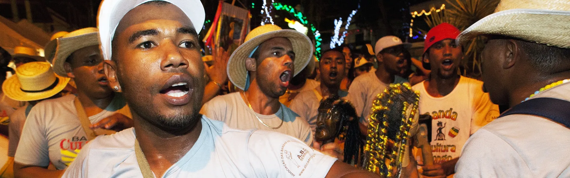 Congueiros cantando na banda de congo, à noite, durante a festa