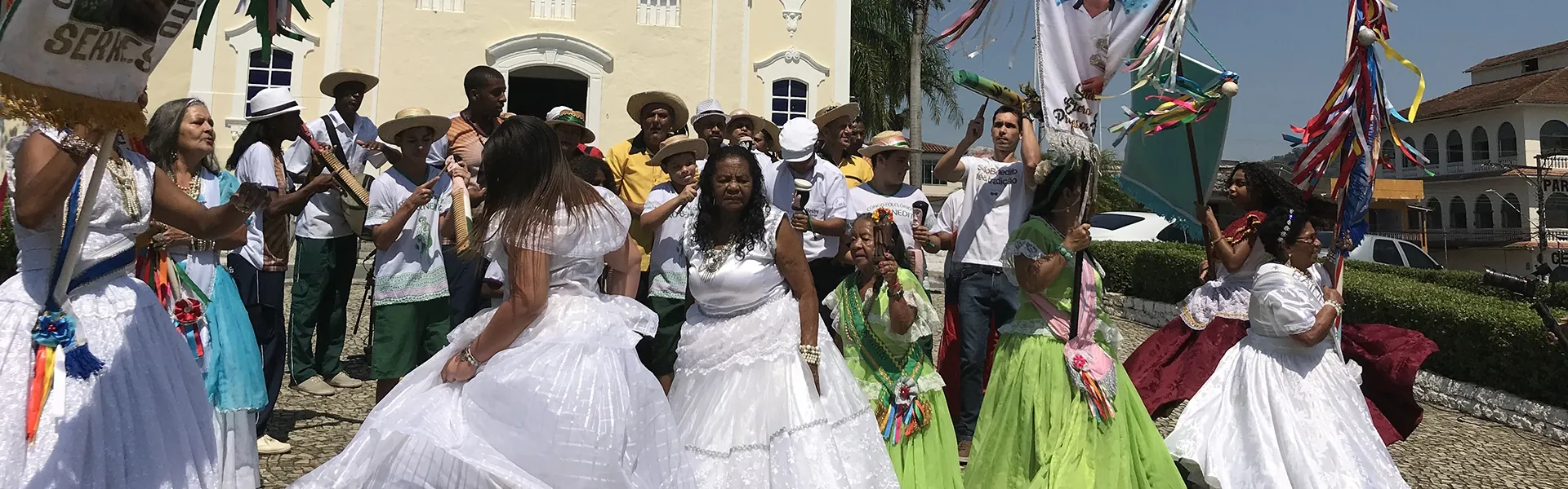 Cortejo das bandas de congo com as baianas de saia branca diante da igreja